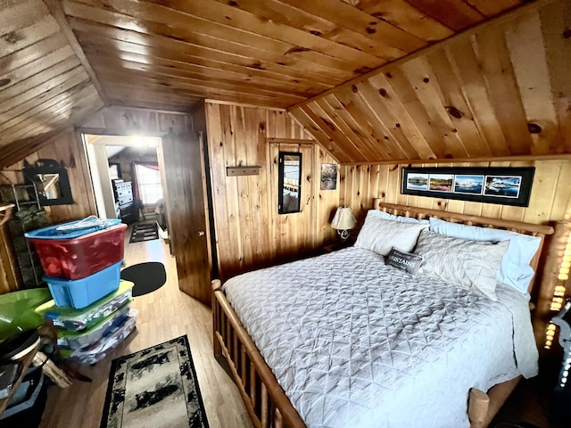 bedroom featuring lofted ceiling, wood ceiling, light hardwood / wood-style floors, and wood walls