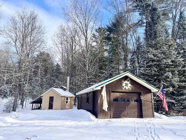 exterior space with a garage and an outbuilding