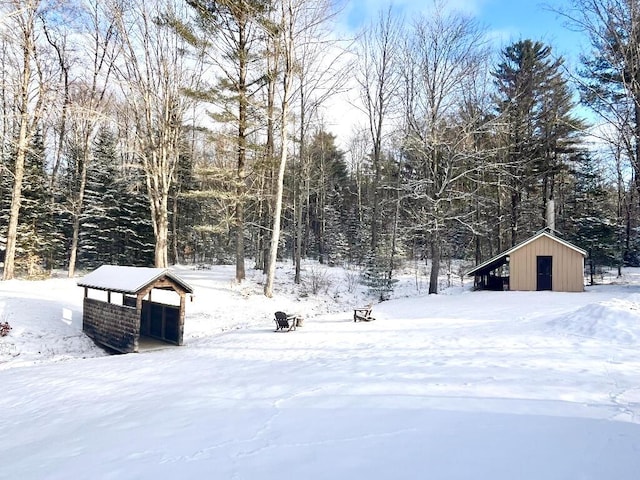 snowy yard featuring an outbuilding