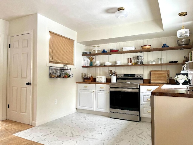 kitchen with white cabinetry, butcher block counters, stainless steel electric range, and pendant lighting