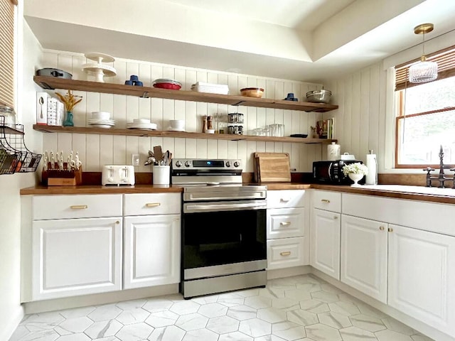 kitchen featuring white cabinetry, stainless steel electric stove, decorative light fixtures, and sink