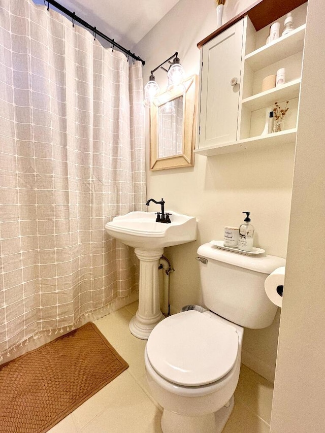 bathroom featuring a shower with shower curtain, tile patterned floors, and toilet