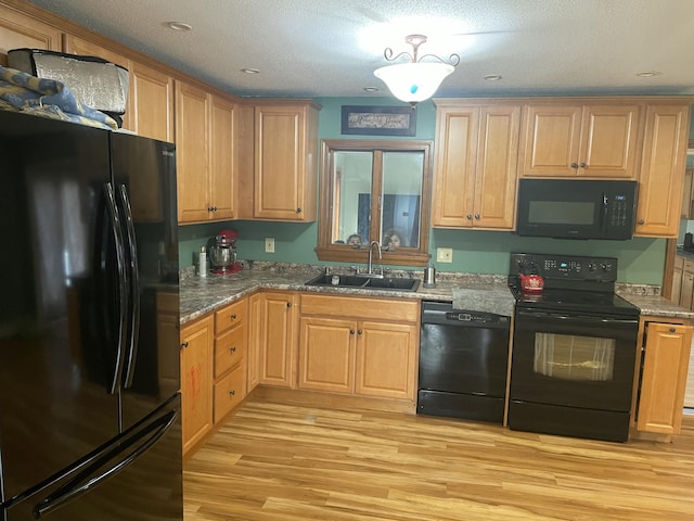 11 Partridge Dr, Gardiner, ME 04345 - kitchen featuring a textured ceiling, light stone counters, a sink, light wood-type flooring, and black appliances