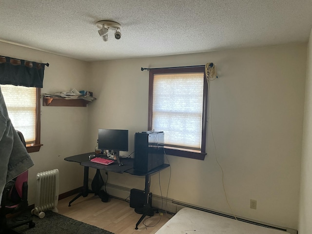 11 Partridge Dr, Gardiner, ME 04345 - home office with radiator, a textured ceiling, baseboards, and wood finished floors