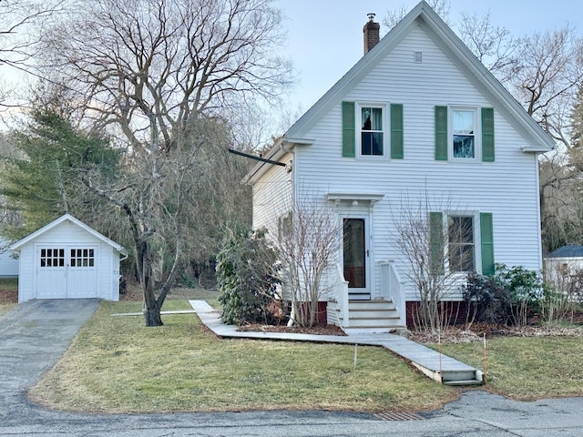 view of front of home featuring an outbuilding, a garage, and a front yard