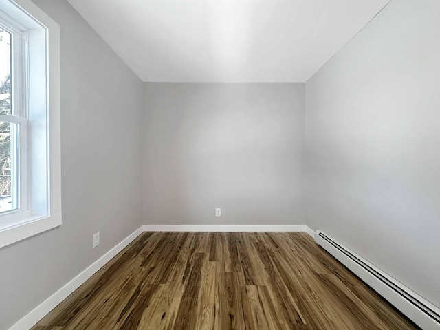 additional living space featuring a baseboard heating unit and hardwood / wood-style floors