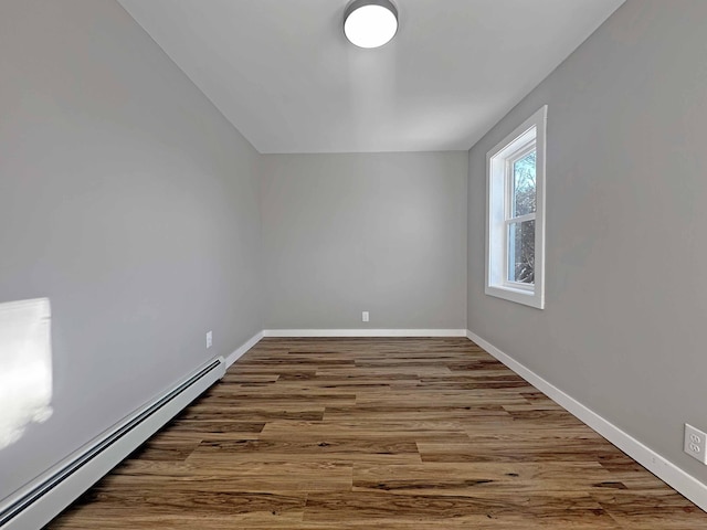 empty room featuring hardwood / wood-style flooring and a baseboard radiator