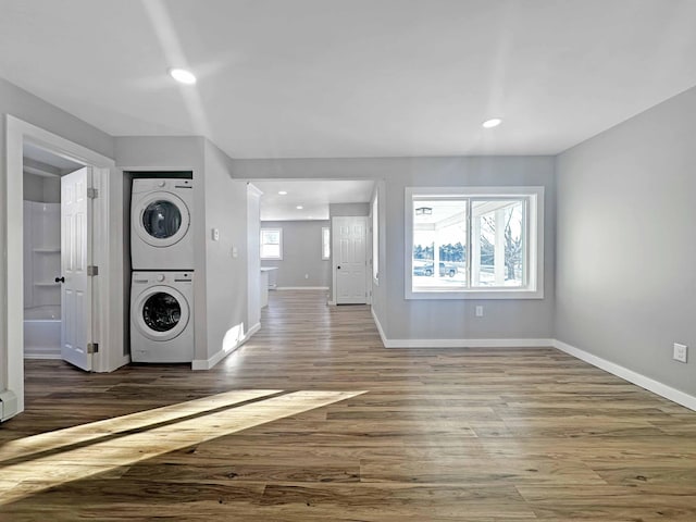 washroom featuring dark hardwood / wood-style floors and stacked washing maching and dryer