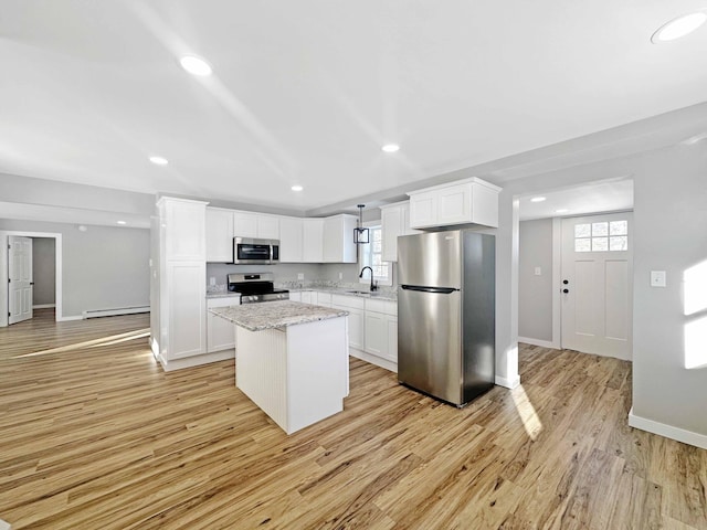 kitchen featuring white cabinetry, sink, a center island, light stone counters, and stainless steel appliances