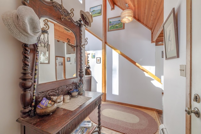 entryway with a baseboard radiator, vaulted ceiling, and wooden ceiling