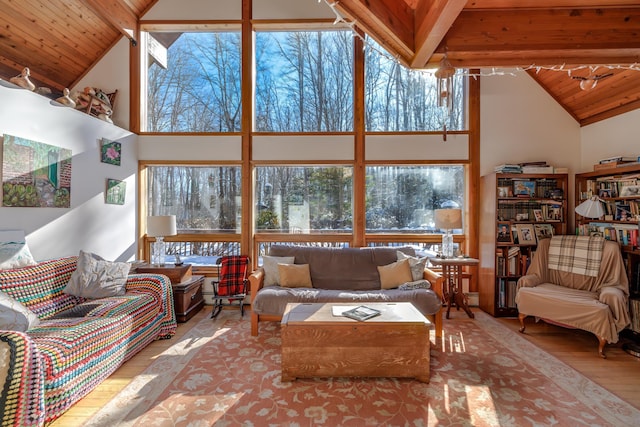 living room featuring wood ceiling, high vaulted ceiling, a healthy amount of sunlight, and light hardwood / wood-style floors