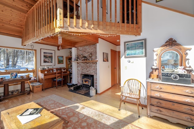 living room featuring high vaulted ceiling, a wood stove, wood ceiling, and light hardwood / wood-style flooring