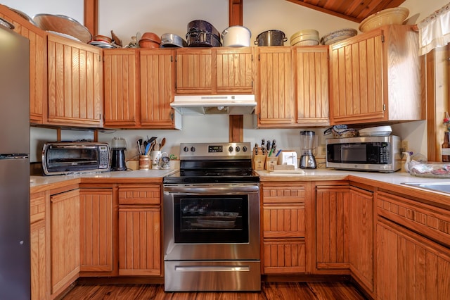 kitchen featuring dark hardwood / wood-style flooring, vaulted ceiling, and appliances with stainless steel finishes