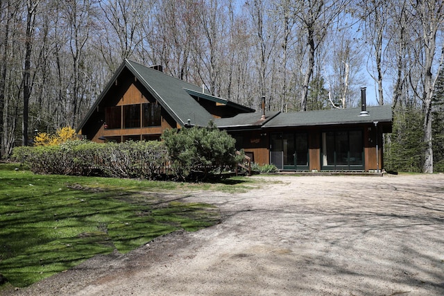 view of front of property featuring a shingled roof and a chimney