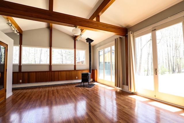unfurnished sunroom with a wood stove, a baseboard radiator, plenty of natural light, and french doors