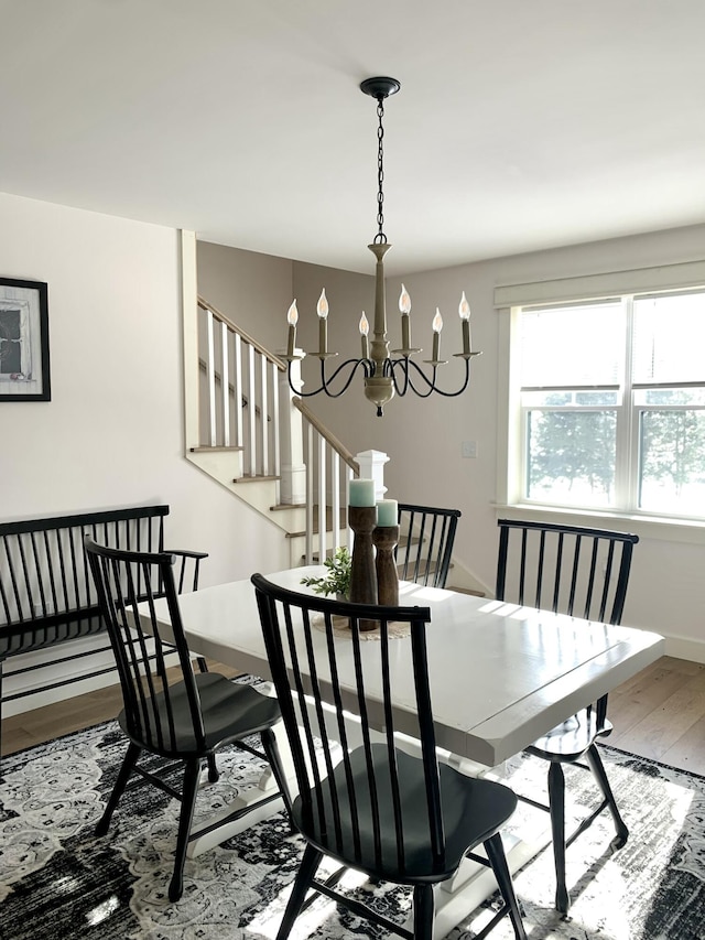 dining area with wood-type flooring and a chandelier