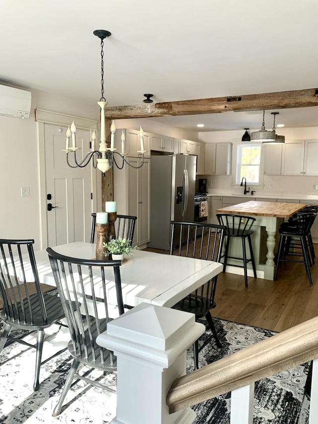 dining space featuring wood-type flooring, sink, a wall mounted air conditioner, and beam ceiling