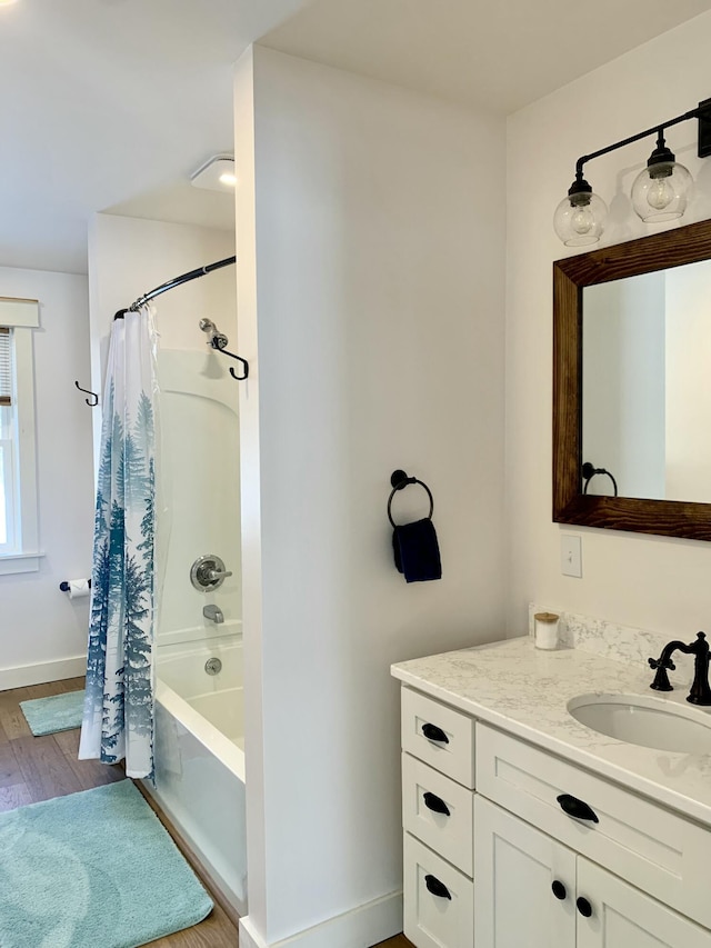 bathroom featuring hardwood / wood-style flooring, vanity, and shower / bath combo with shower curtain