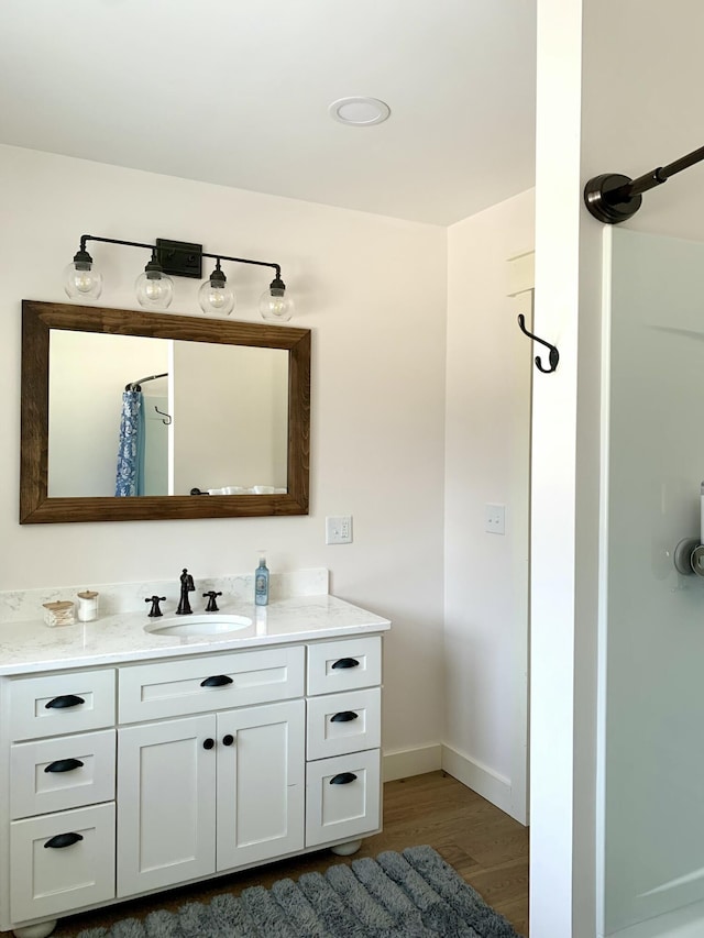 bathroom featuring vanity, wood-type flooring, and walk in shower