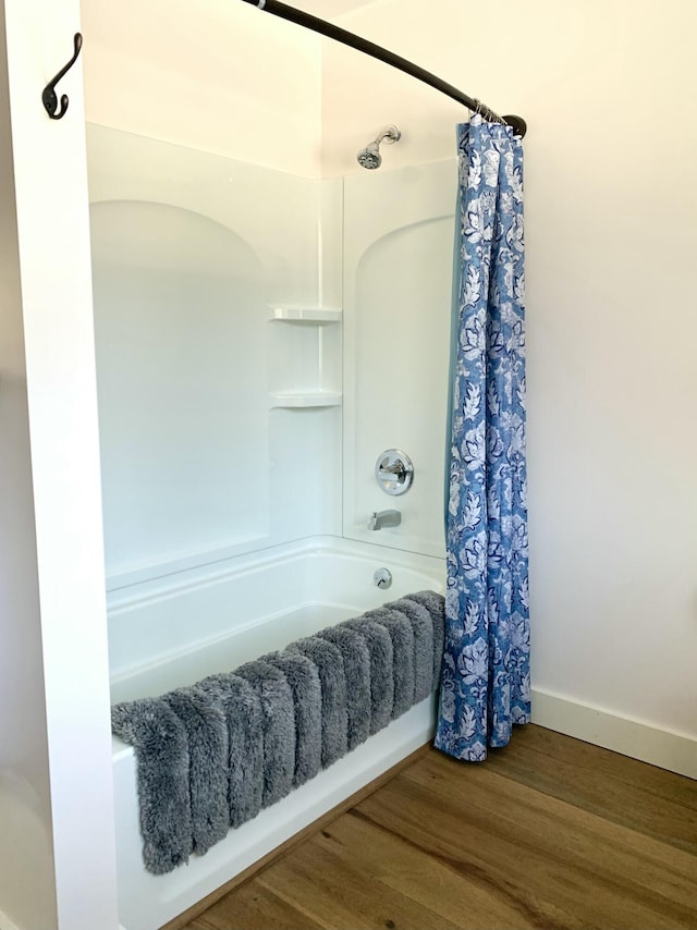 bathroom with hardwood / wood-style floors and shower / tub combo with curtain