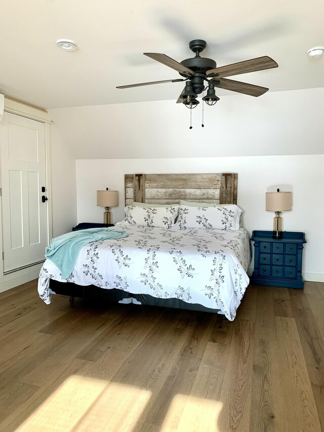 bedroom with hardwood / wood-style flooring, ceiling fan, and lofted ceiling