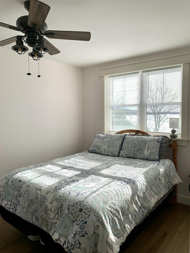 bedroom with ceiling fan and dark hardwood / wood-style flooring