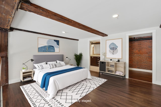 bedroom with beamed ceiling, brick wall, dark wood-type flooring, and connected bathroom