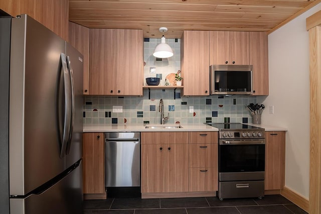 kitchen featuring sink, dark tile patterned flooring, pendant lighting, stainless steel appliances, and decorative backsplash