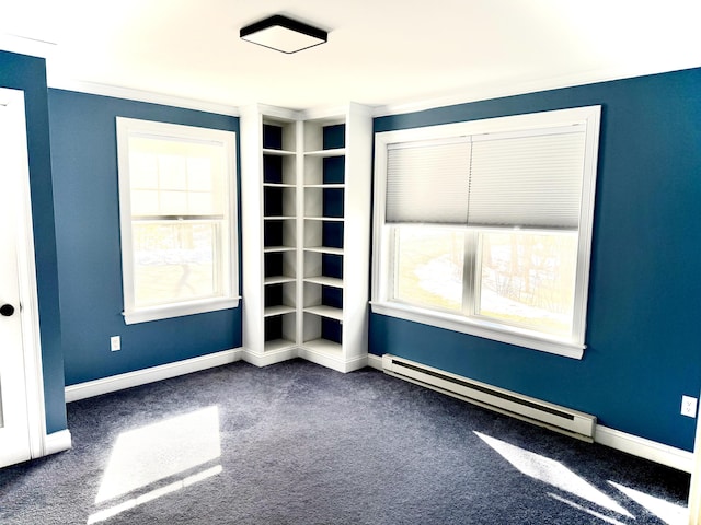 unfurnished room with a baseboard radiator, baseboards, and dark carpet