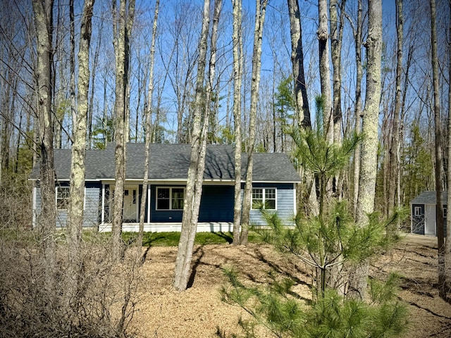 501 Burnt Mill Rd, Wells, ME 04090 - exterior space featuring covered porch, a shingled roof, an outdoor structure, and a storage unit