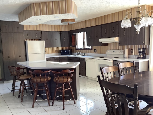 kitchen with a kitchen island, sink, white appliances, dark brown cabinetry, and a textured ceiling