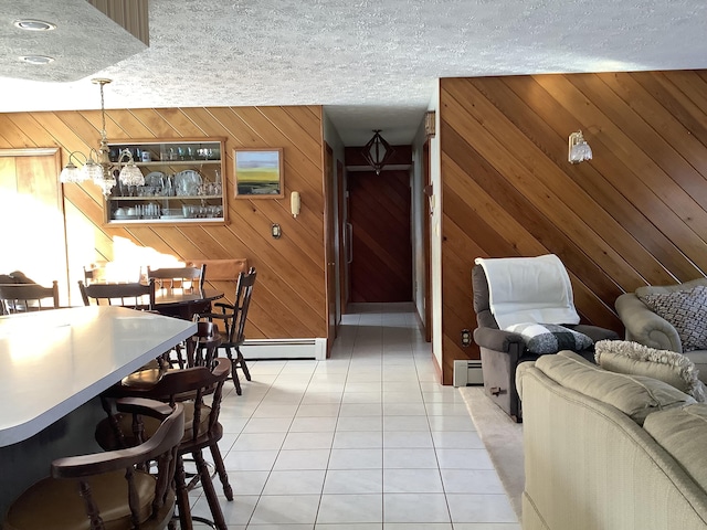 tiled living room with a baseboard heating unit, a textured ceiling, and wooden walls