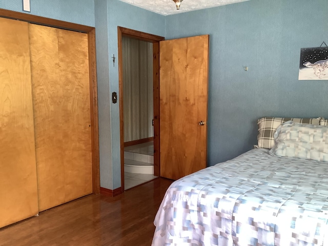 bedroom with wood-type flooring and a closet