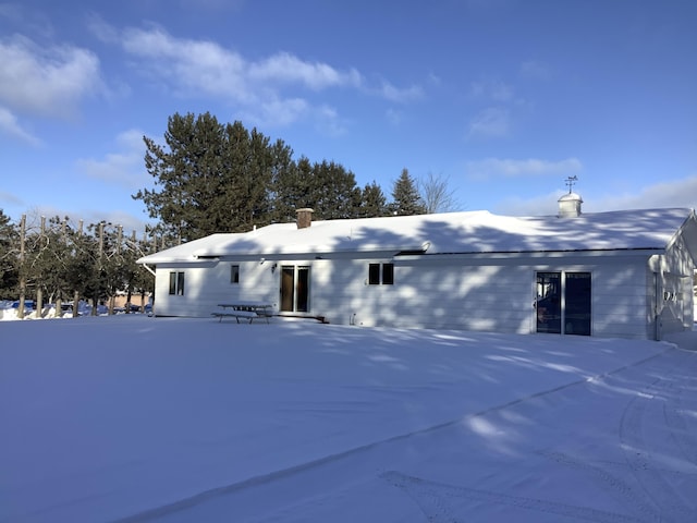 view of snow covered back of property