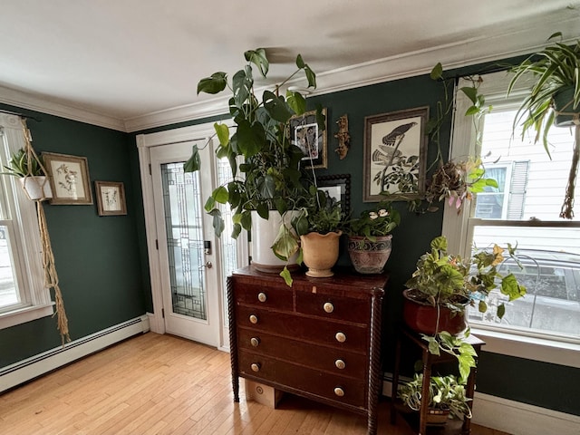 doorway featuring light hardwood / wood-style flooring, crown molding, and a baseboard radiator