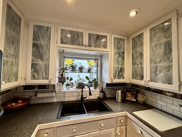 kitchen featuring white cabinetry, sink, and backsplash