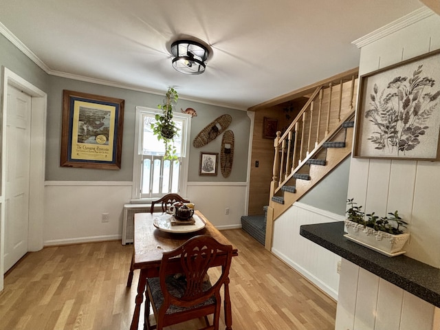 dining space featuring ornamental molding and light hardwood / wood-style floors