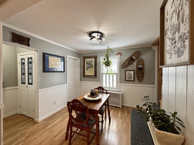 dining room with crown molding and light hardwood / wood-style floors