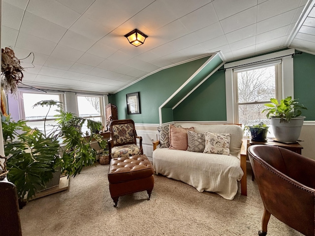 living area featuring lofted ceiling, carpet flooring, and a wealth of natural light