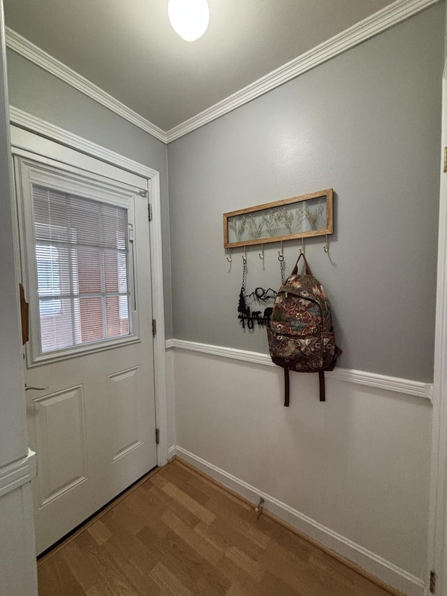 entryway with hardwood / wood-style flooring and ornamental molding