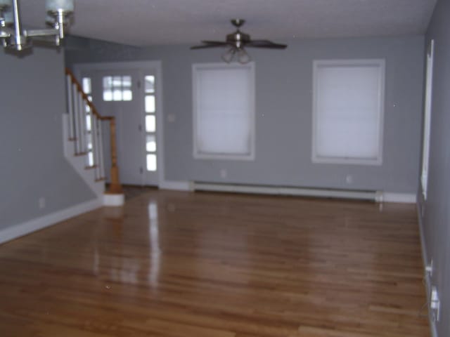 entryway featuring dark hardwood / wood-style flooring, a baseboard heating unit, and ceiling fan