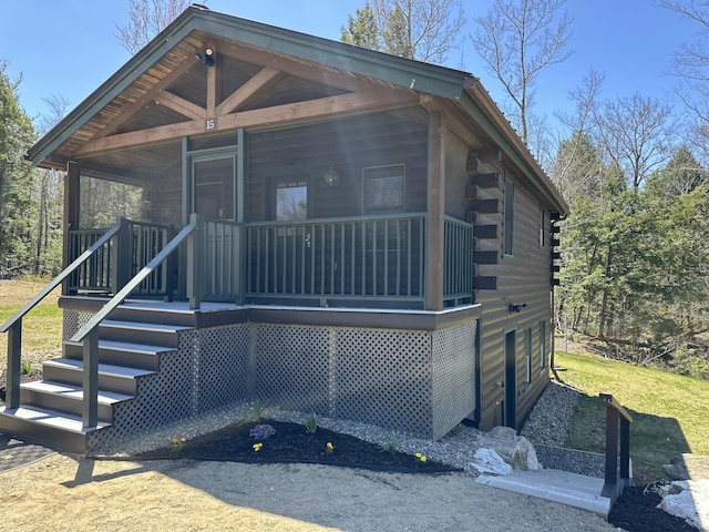 view of front of property featuring covered porch and log exterior