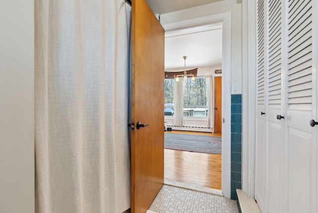 corridor featuring light tile patterned floors and baseboard heating