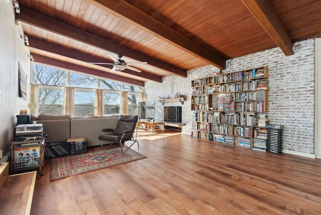 sitting room with hardwood / wood-style flooring, brick wall, wood ceiling, and a fireplace