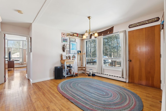 interior space with light hardwood / wood-style flooring, a chandelier, and baseboard heating