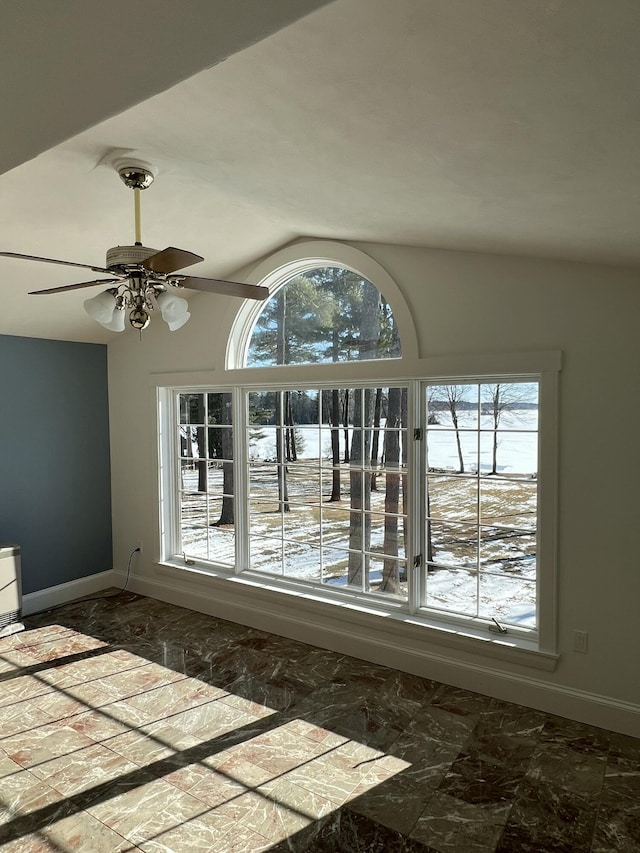 unfurnished room with ceiling fan, a healthy amount of sunlight, and vaulted ceiling