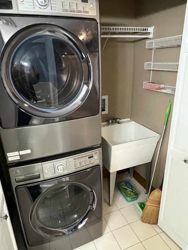 laundry room featuring light tile patterned flooring and stacked washer and clothes dryer