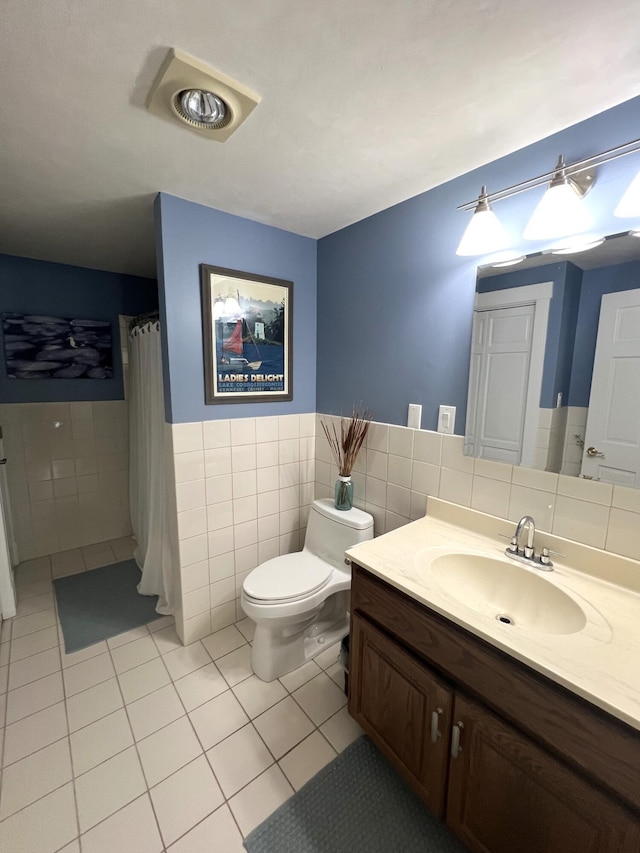 bathroom with tile walls, a shower with shower curtain, vanity, tile patterned floors, and toilet