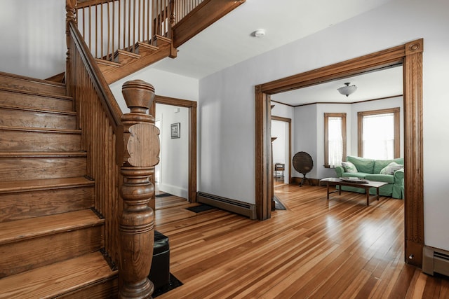 stairway featuring hardwood / wood-style floors and baseboard heating