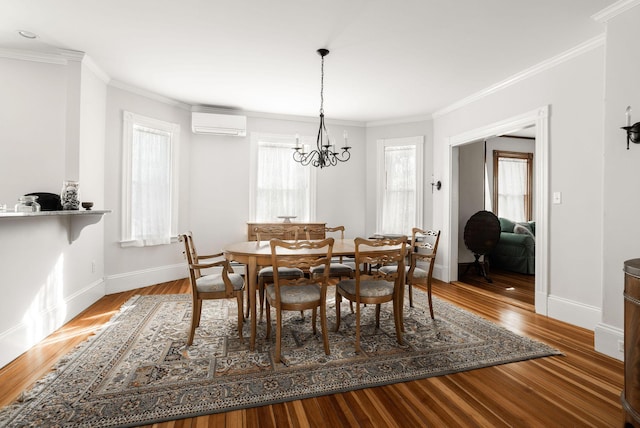 dining area with wood-type flooring, ornamental molding, a notable chandelier, and a wall unit AC